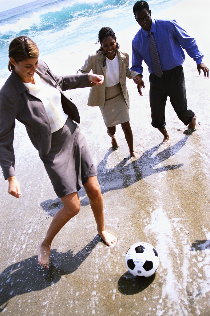 Businesspeople Playing Soccer on the Beach